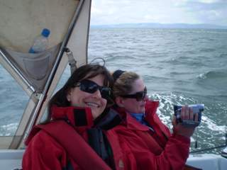 Small group of students smiling in the cockpit of a training yacht